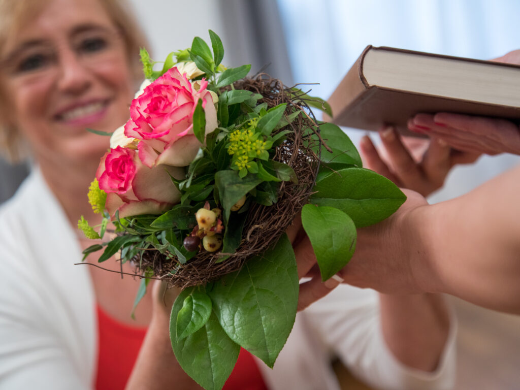 Eine Frau verschenkt Blumen zum Muttertag