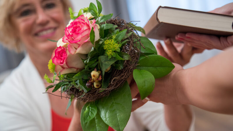 Eine Frau verschenkt Blumen zum Muttertag