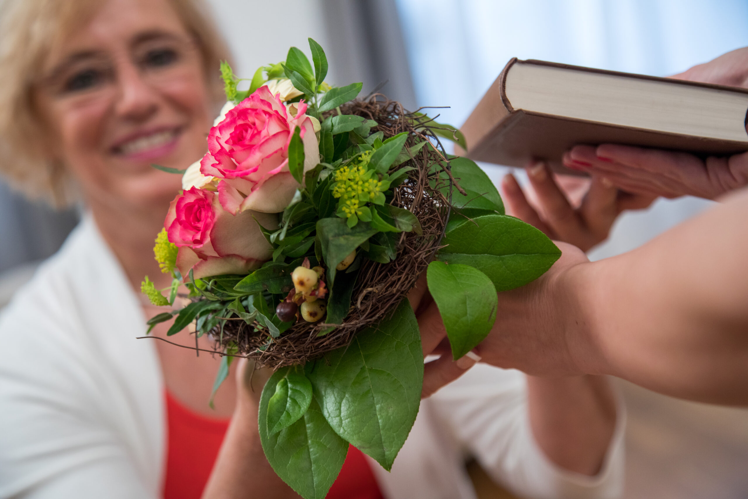 Eine Frau verschenkt Blumen zum Muttertag