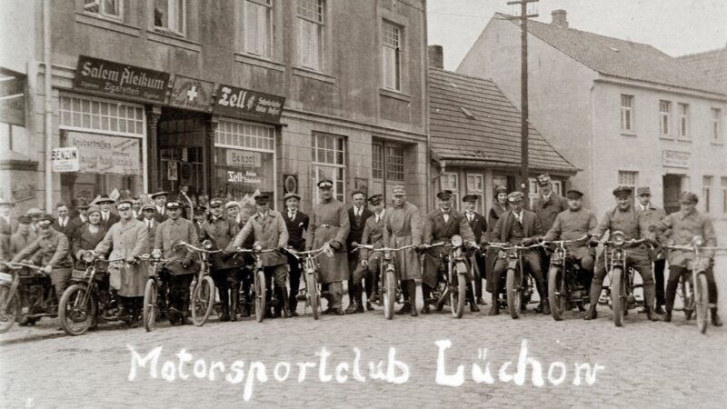 Im Mai unternehmen viele eine MAitour - schon vor 100 Jahren: Ausfahrt des Motorsportclub Lüchow 1925 nach Arendsee. Im Gebäude hinter der Gruppe befindet sich die Sanitätsdrogerie von Paul Hilberg.