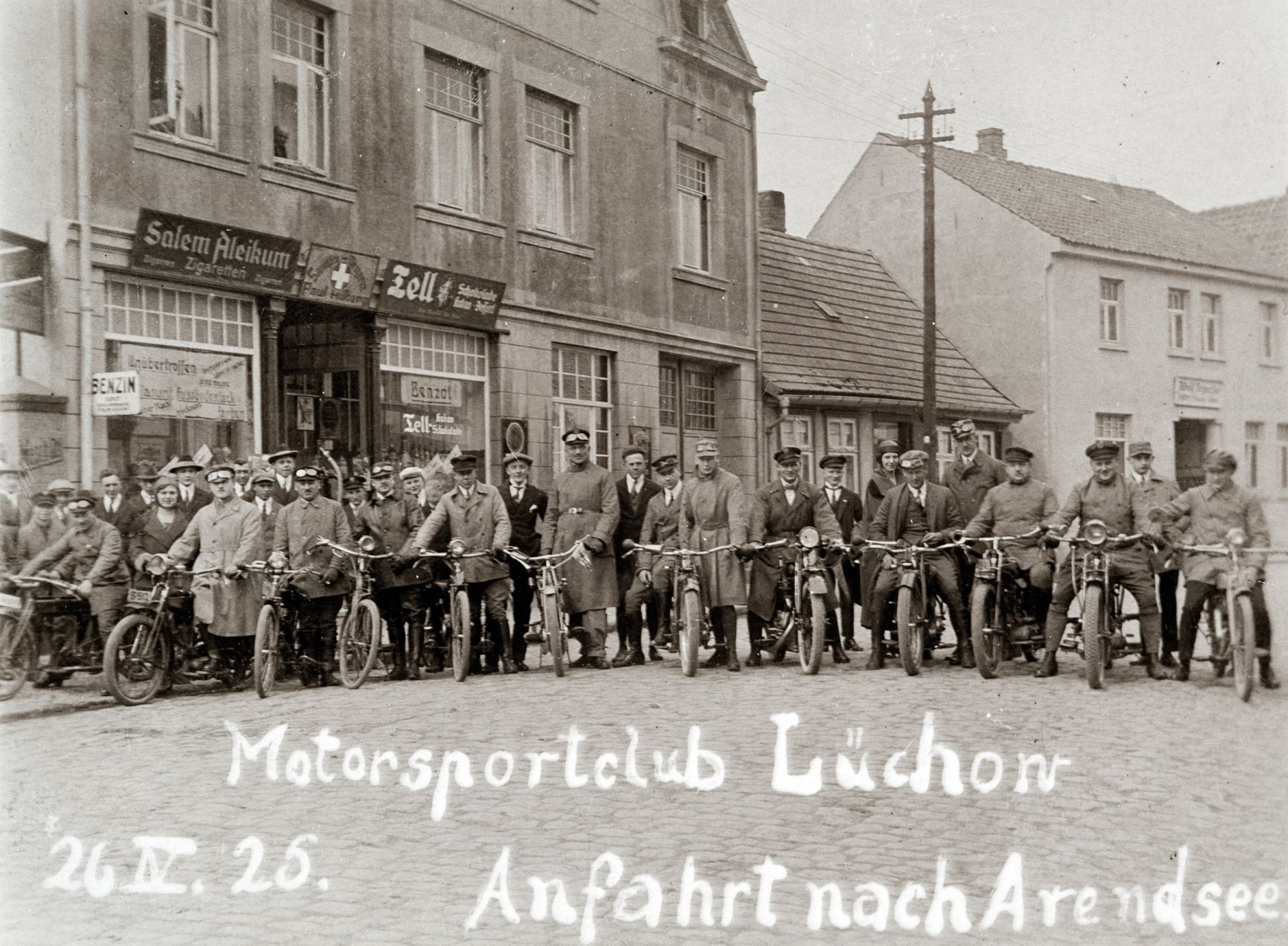 Im Mai unternehmen viele eine MAitour - schon vor 100 Jahren: Ausfahrt des Motorsportclub Lüchow 1925 nach Arendsee. Im Gebäude hinter der Gruppe befindet sich die Sanitätsdrogerie von Paul Hilberg.