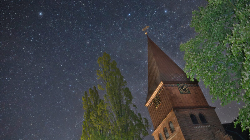 nach aufwendiger Renovierung erstrahlt die Michaeliskirche von Schnega
jetzt wieder in neuem Glanz.  Meine Aufnahme ist gestern Morgen um 02:12 Uhr entstanden. Links oben
ist der Polarstern zu sehen. Das Sternbild Cepheus erstreckt sich über
den gesamten übrigen Himmelsbereich. Schon bei mittlerer Bildschirmgröße
ist rechts am Kastanienlaub Herschels Granatstern mit seinem auffällig
rötlichen Schimmer erkennbar.