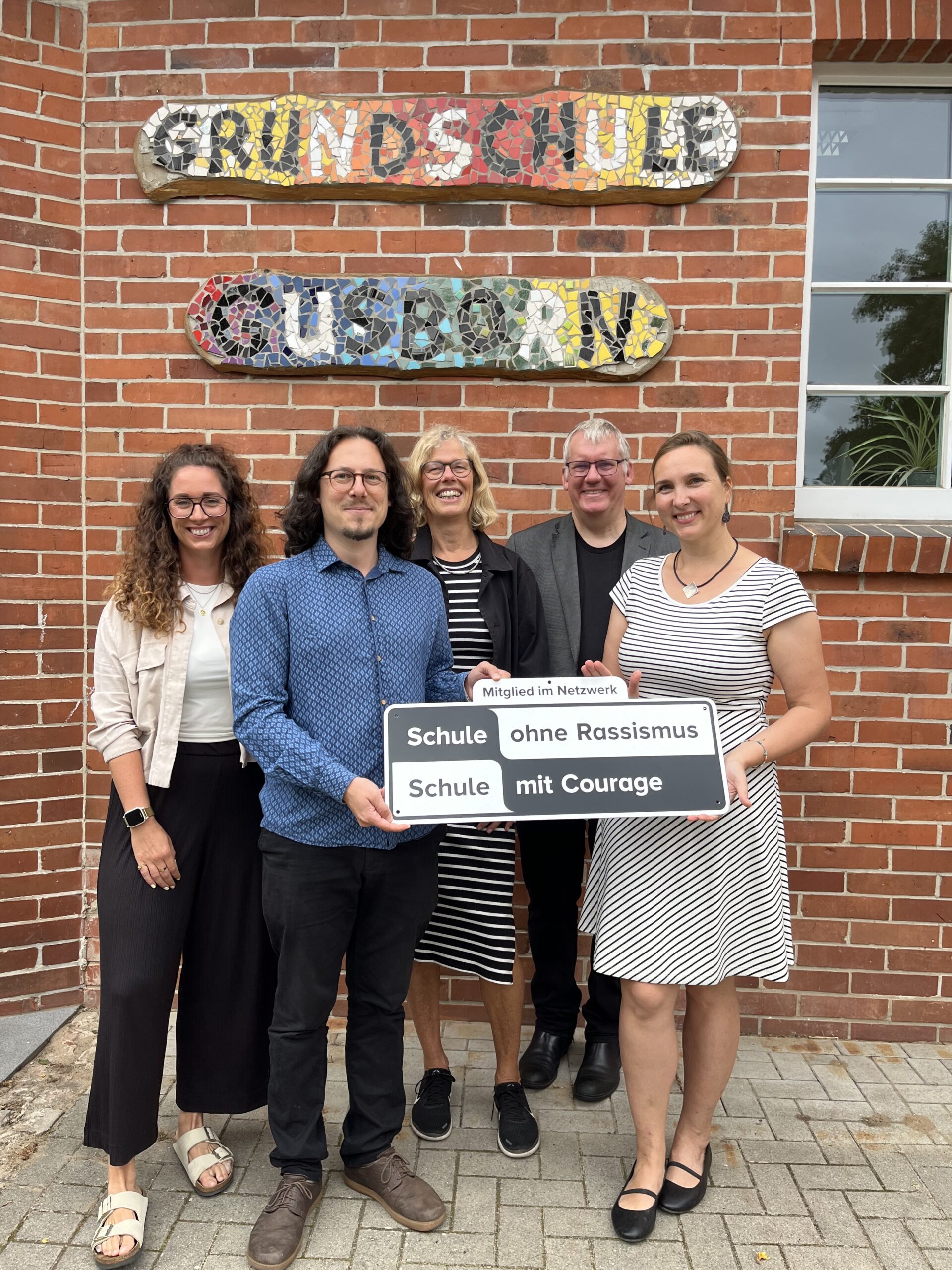 Konstantin Leimig von der Kurve Wustrow (2. von links) überreichte die Plaktette an Schulleiterin Andrea Hahlbohm (rechts). Die Aktion vorbereitet hatten Lehrerin Maike Bodendieck (Mitte) und Schulsozialarbeiterin Mandy Schott (links), Schulpate wurde Pastor Jörg Prahler.