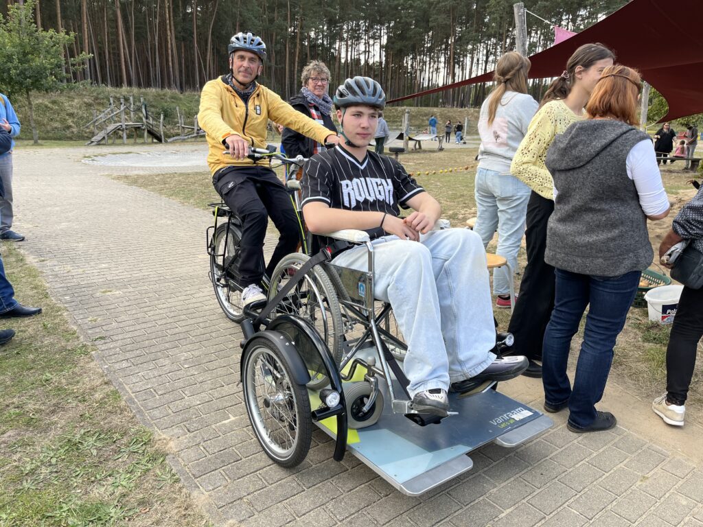 Wer wollte, durfte sich von Lehrer Marcel Kohla im E-Rollstuhl-Trike herumfahren lassen - Besucher Kevin probierte es aus.