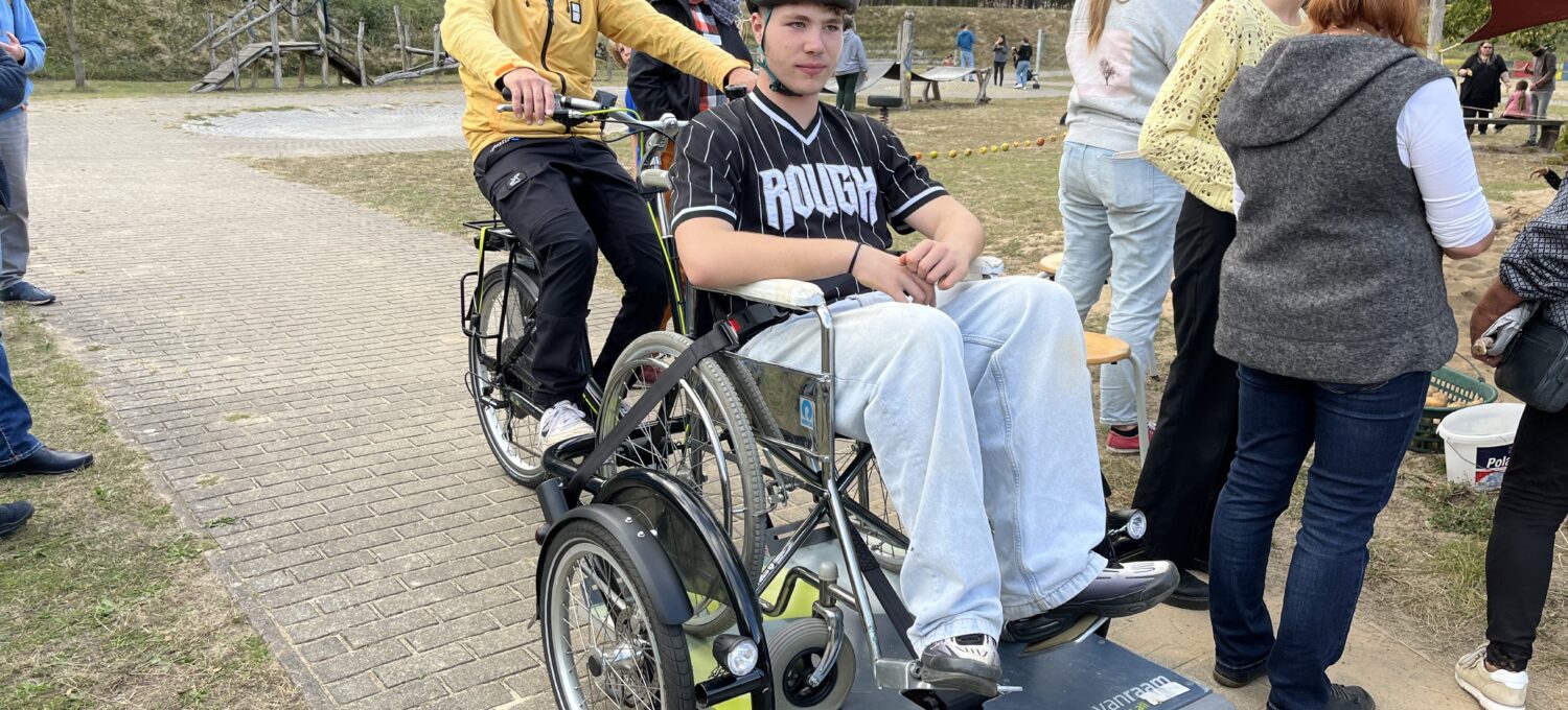 Wer wollte, durfte sich von Lehrer Marcel Kohla im E-Rollstuhl-Trike herumfahren lassen - Besucher Kevin probierte es aus.