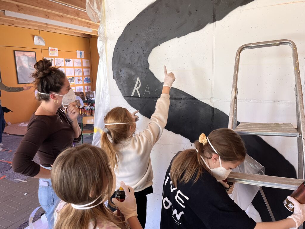 In Gusborns Grundschule gegen Rassismus: Fella, Juna und Amelie zeigen Schulsozialarbeiterin Mandy Schott die Fortschritte ihres Graffitis.